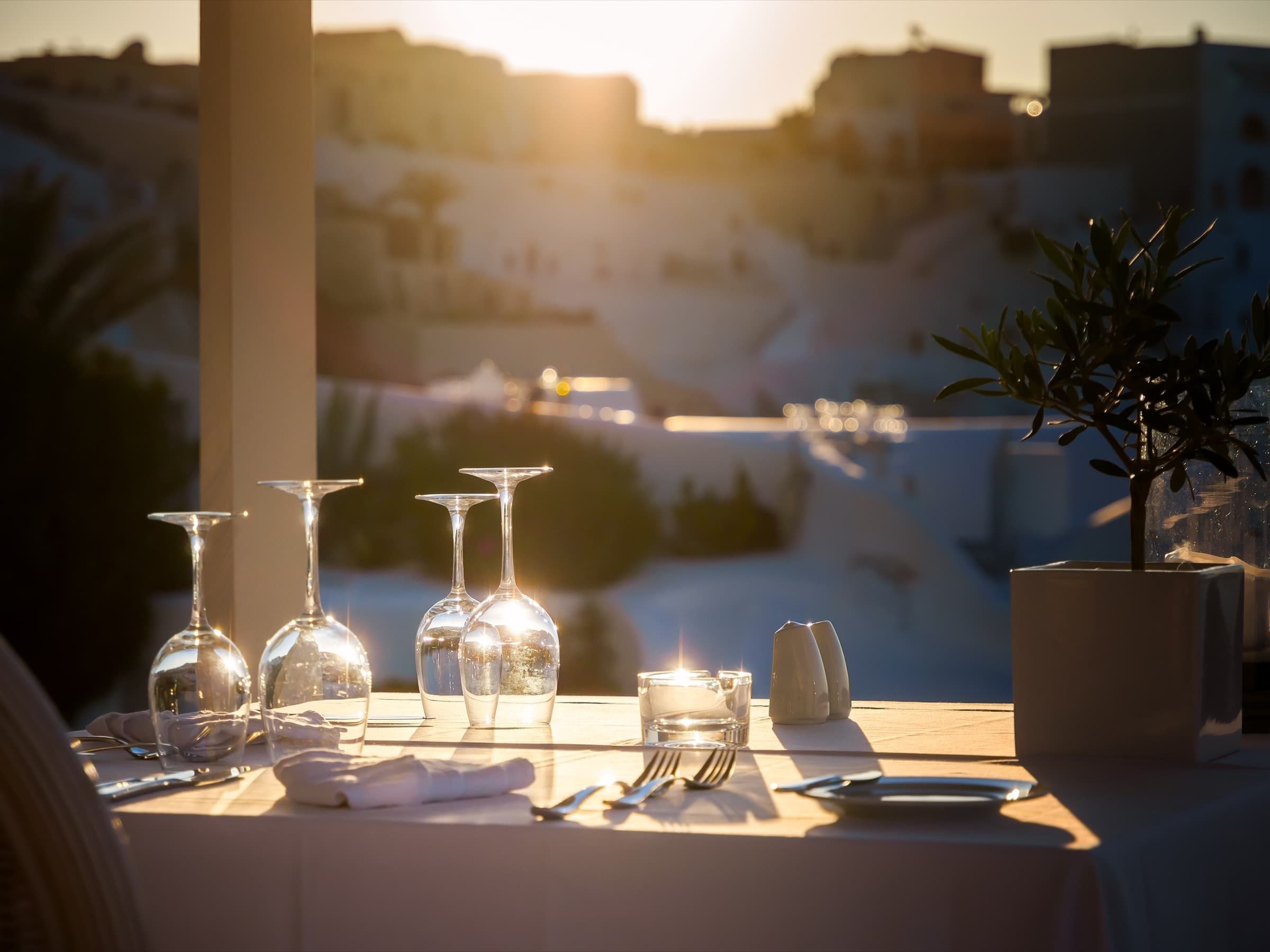 A table laid for dinner on a terrace at golden hour
